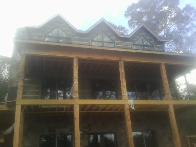 Dormers and porch framing on a large log home under construction — Roof Coating work by our crew in East Canton