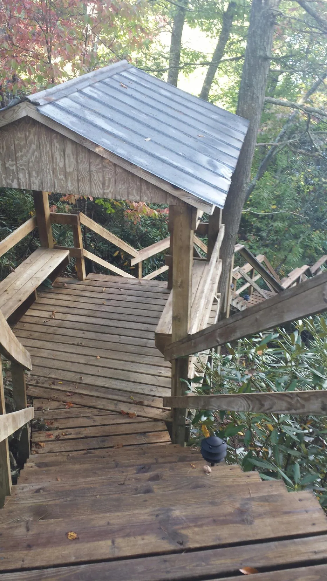 Metal roofed shelter over wooden steps on a wooded walkway — Skylight Repair & Installation work by our crew in East Canton