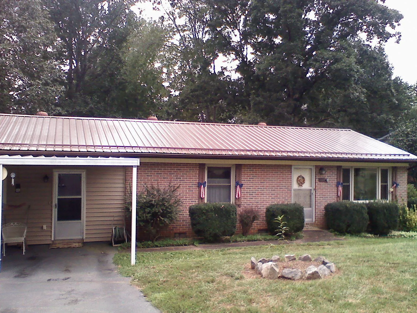 Bronze metal roof and carport on a brick ranch home — Roof Repair work by our crew in East Canton